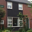Bij deze woning zijn de oude gevelplanken verwijderd en voorzien van metselwerk met nieuwe kunststofkozijnen.